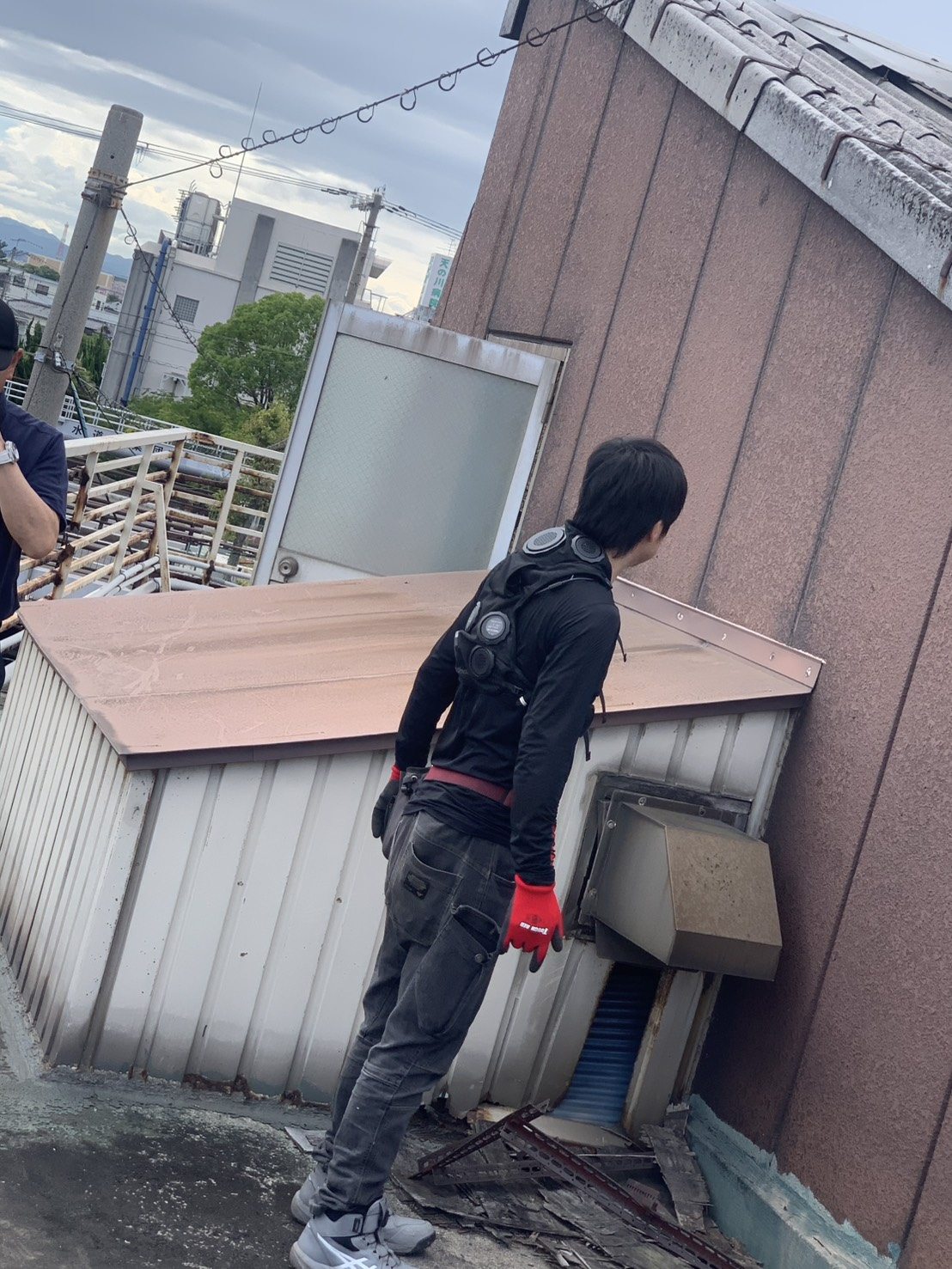 現場でダクトを視察する従業員